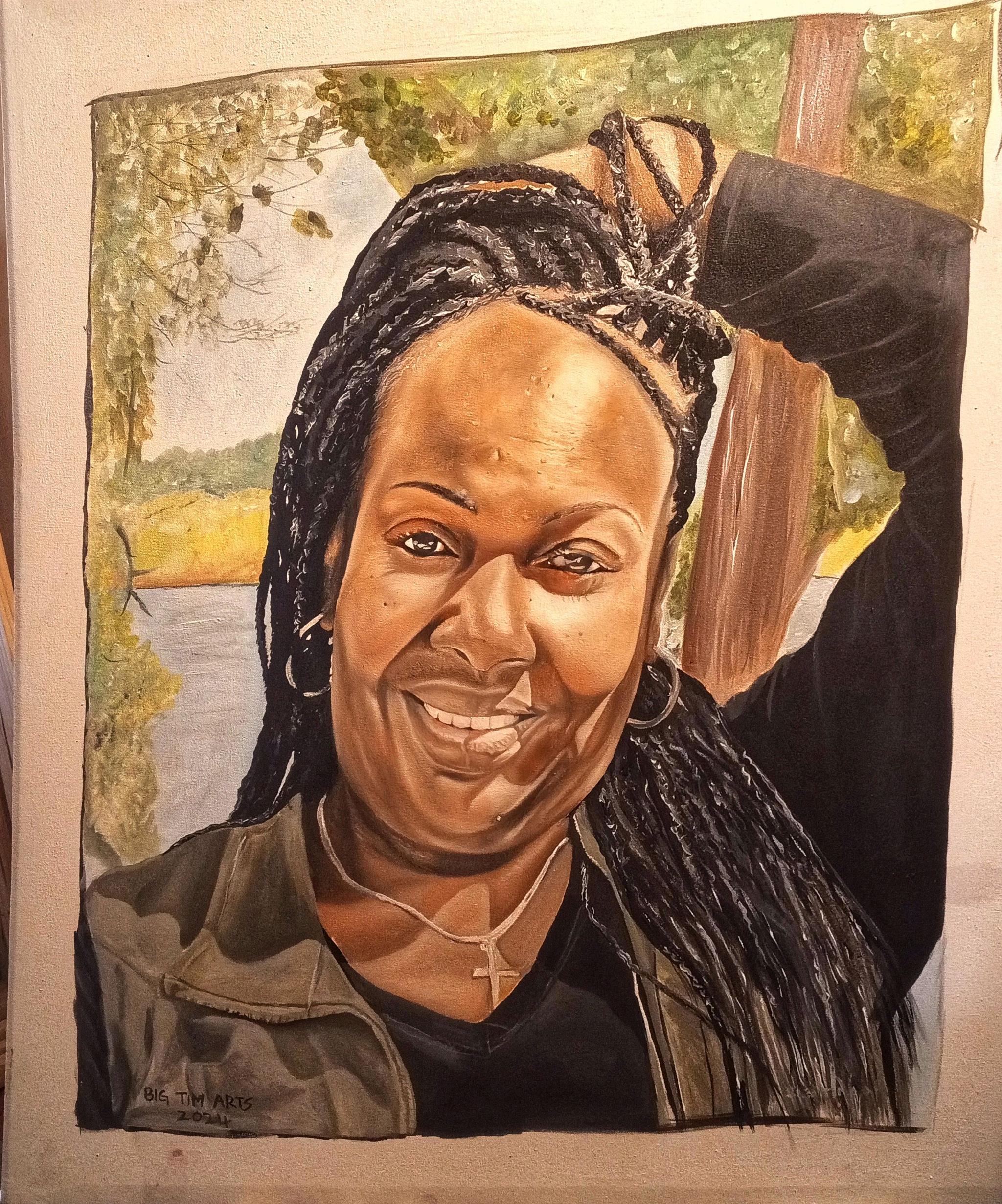 Smiling woman with braids and one arm raised against trees.