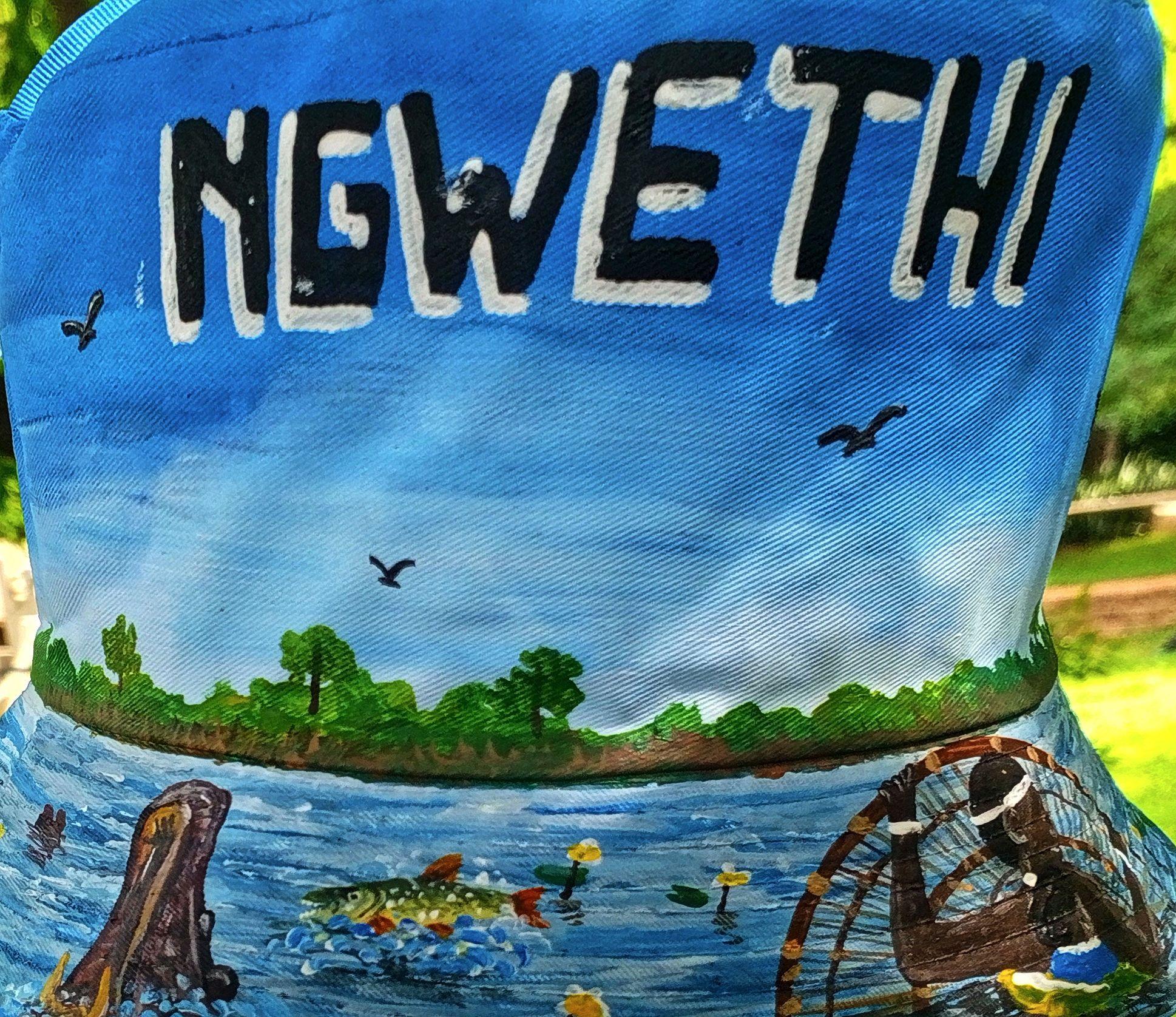 Blue painted fabric with river vegetation, boats and white lettering.