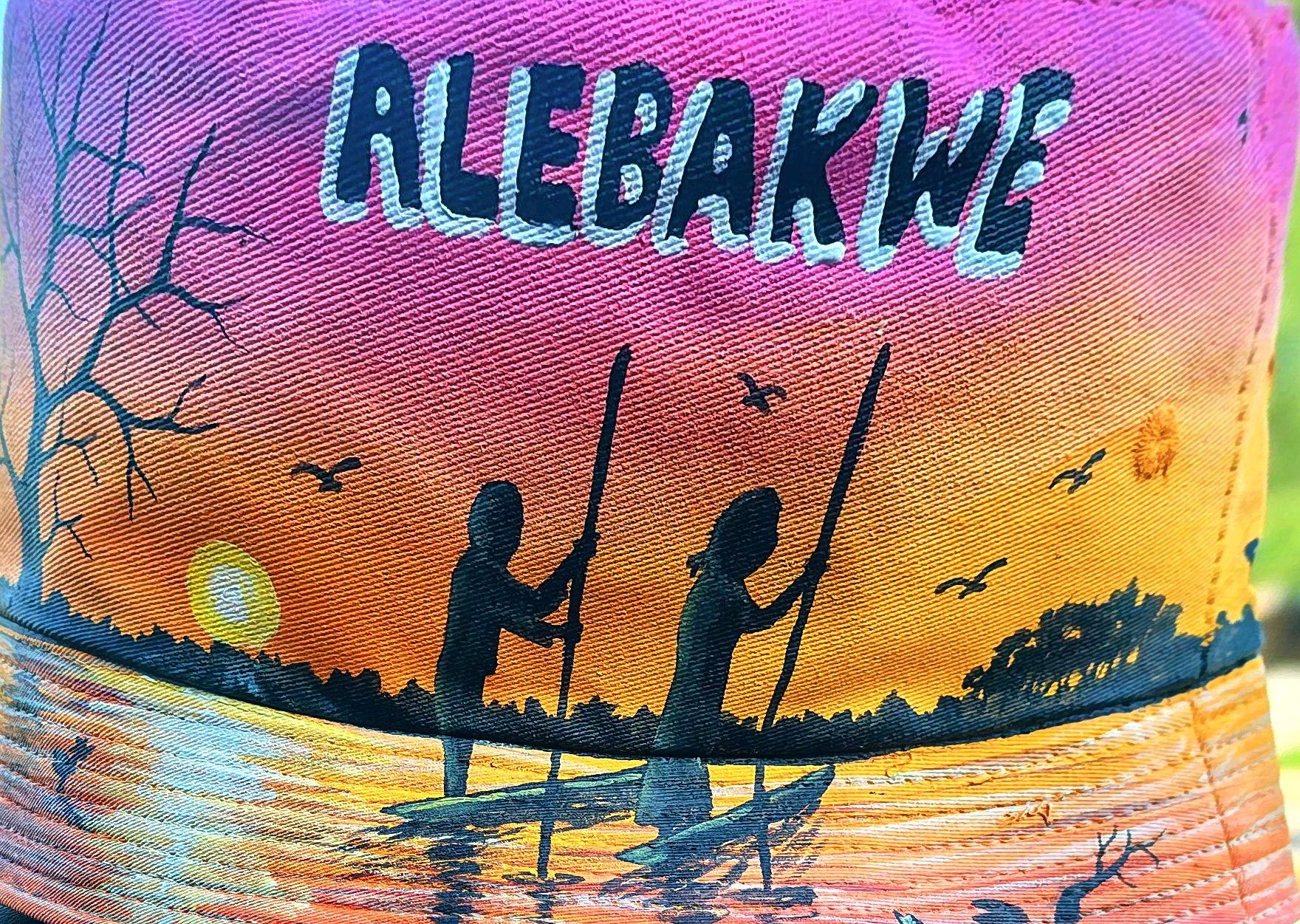 Two canoeing silhouettes against a pink and orange sunset with lettering.