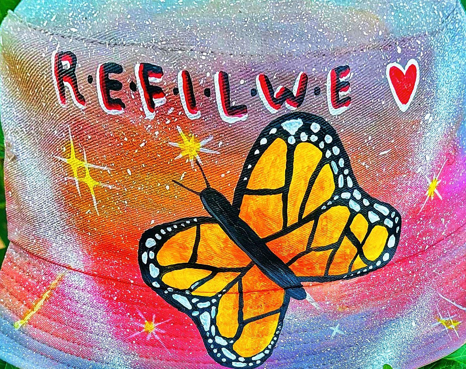 Yellow and black butterfly on colorful fabric with lettering and a heart.