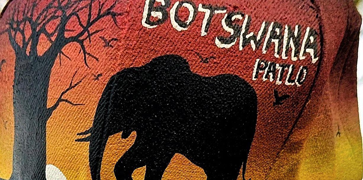 Elephant silhouette on orange painted fabric with Botswana lettering.