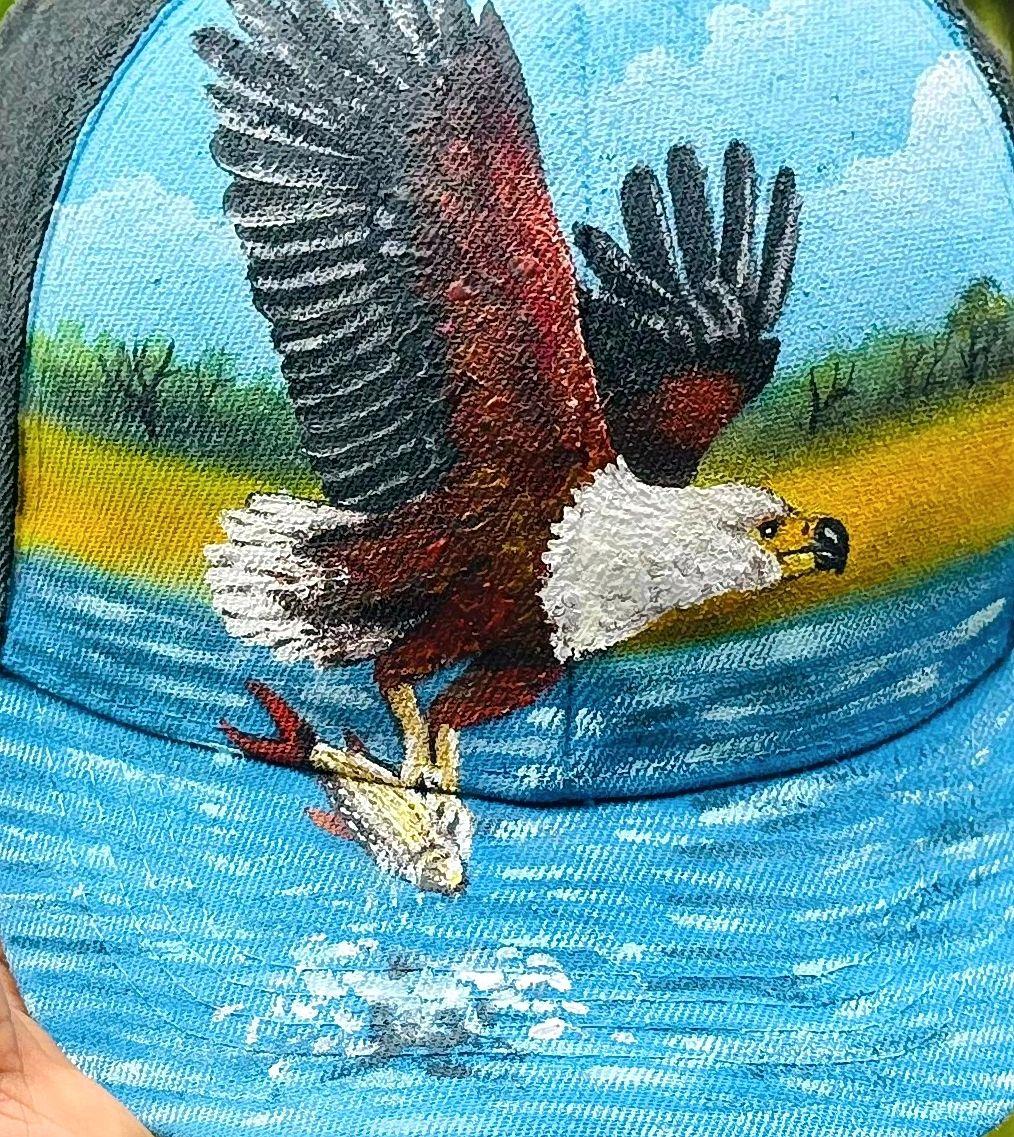 Eagle carrying a fish above blue water.