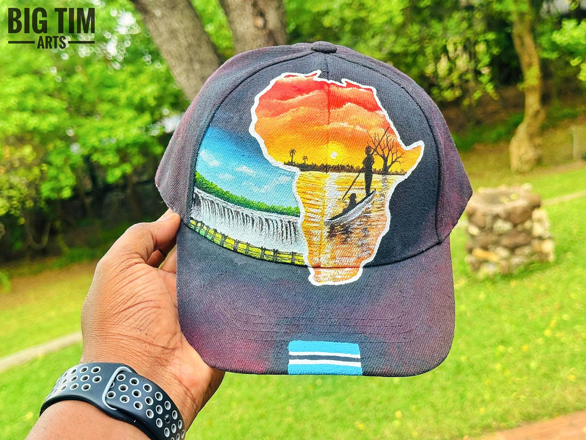 Sunset, waterfall and canoeing imagery inside an Africa-shaped cap design.