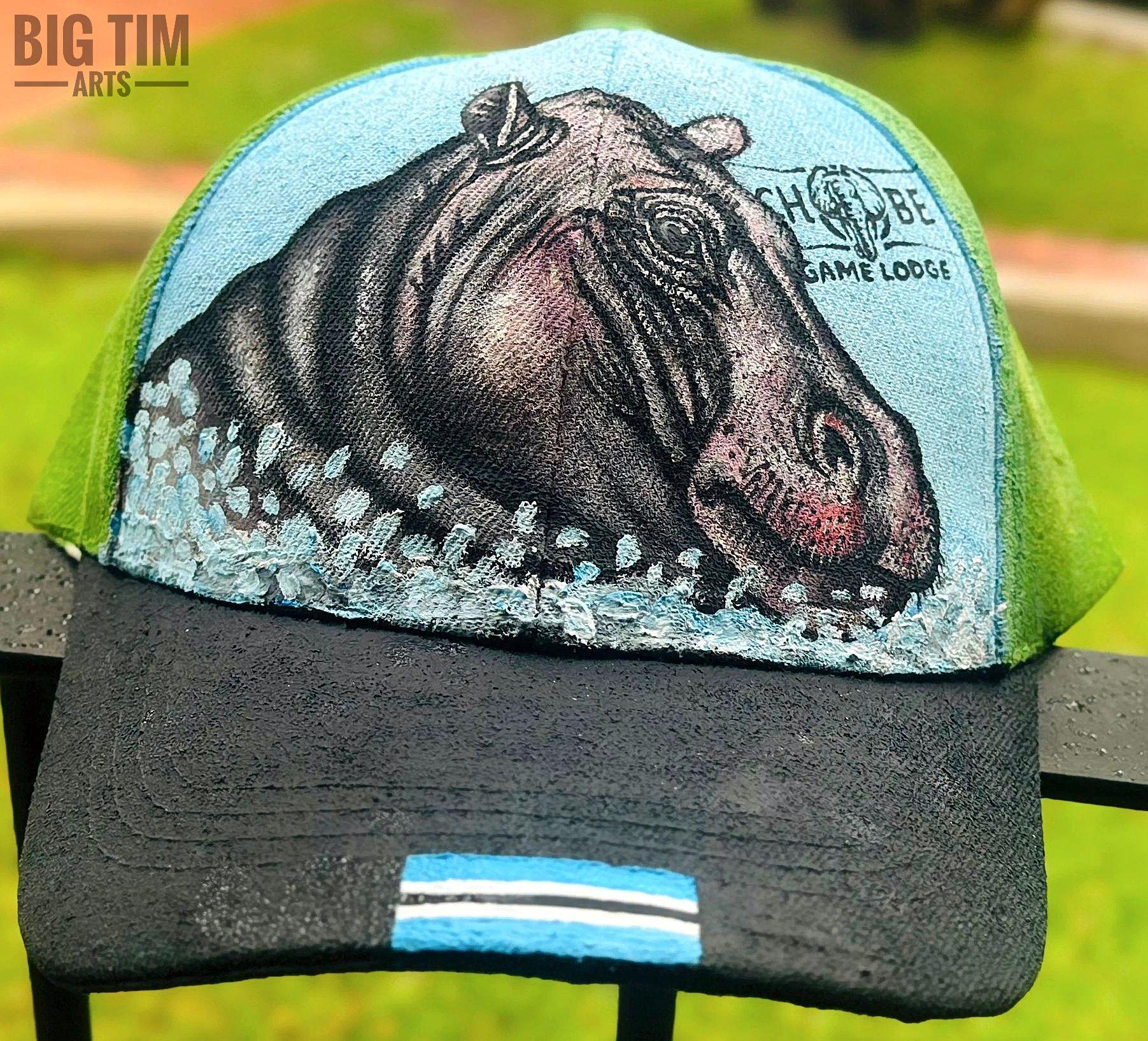 Hippopotamus head amid pale water splashes on a cap.