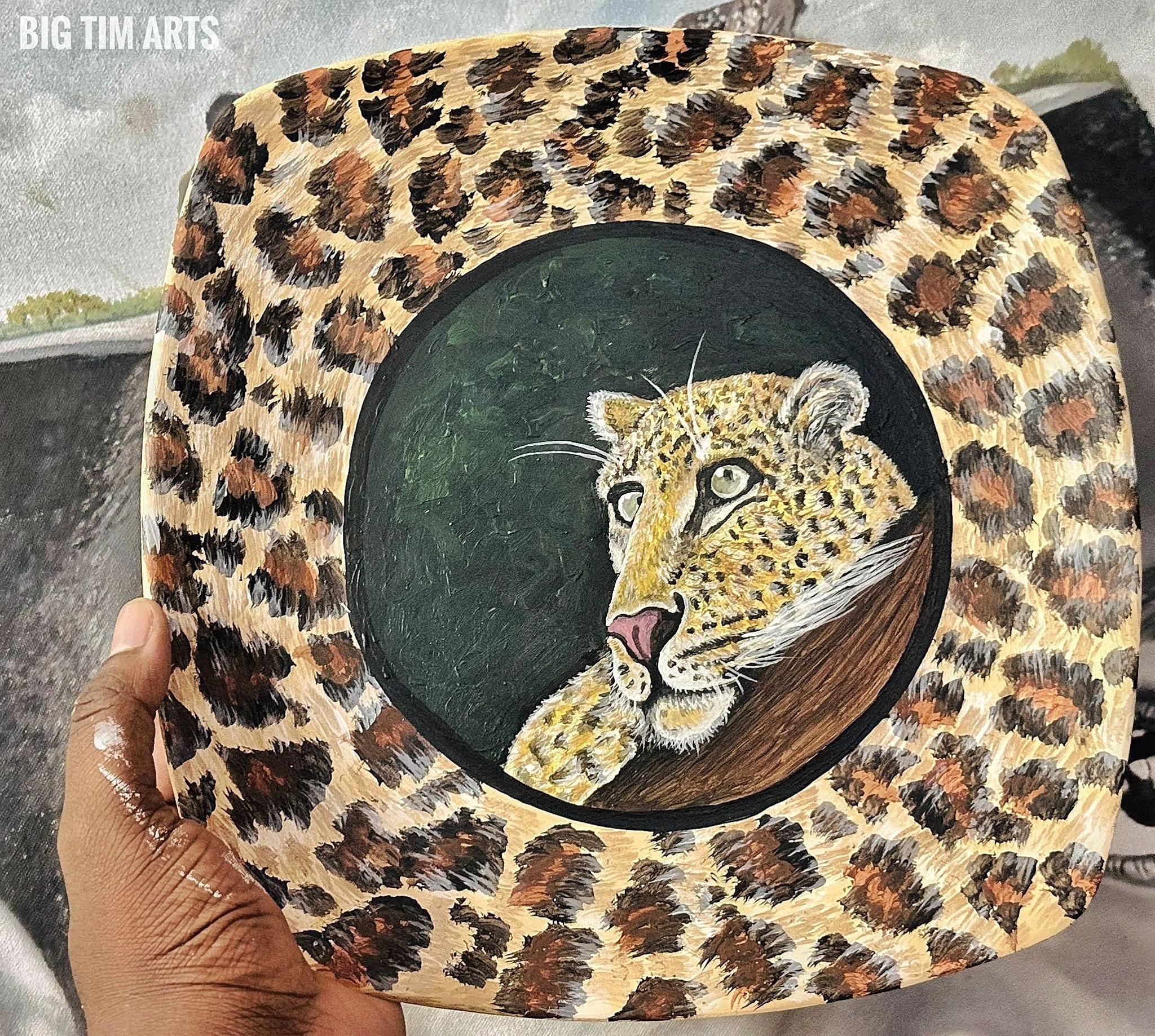 Leopard head inside a dark circle surrounded by a spotted border.